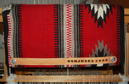 a hand-made Brown Cow Saddle Blanket with hand-tooled wear-leathers that have the award written into the leather